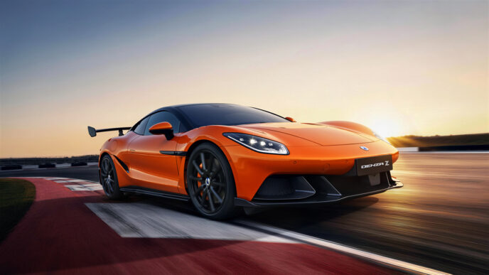 Orange Denza Z, all-electric supercar from BYD's premium brand, speeding down a road at sunset