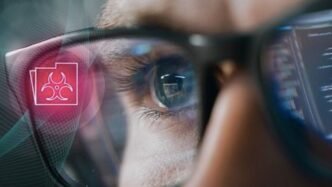 Närbild på man som analyserar cybersäkerhetsdata genom smarta glasögon, symboliserar Check Point Researchs övervakning av cyberhot.