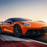 De oranje Denza Z, een volledig elektrische supercar van BYD's premiummerk, raast over een weg bij zonsondergang.