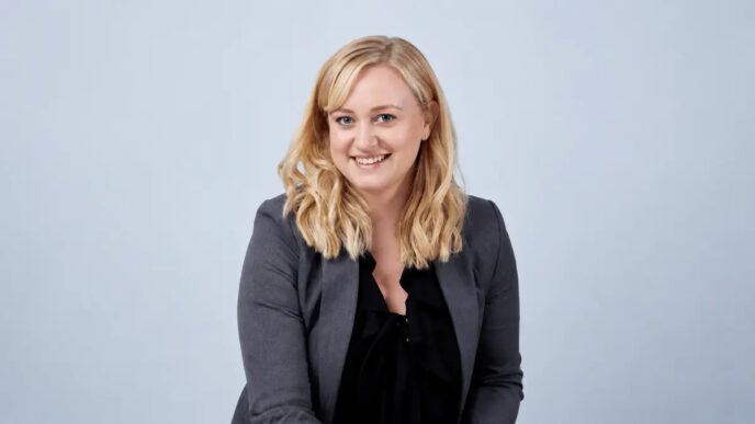Laura Mozden, Global Head of ESG hos Westcon-Comstor, foran en blå baggrund med Westcon-Comstor-logoet. Billedet illustrerer virksomhedens bæredygtighedsarbejde og klimamål for 2030.